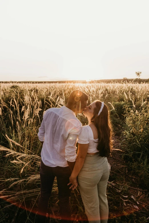 a man and woman standing in tall grass