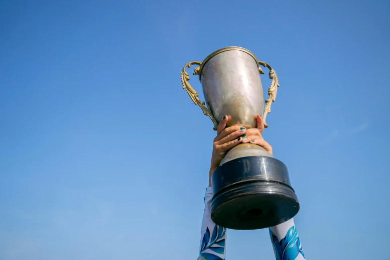 the top part of a hand holding up a trophy