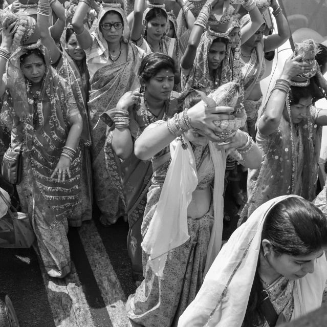 a black and white pograph of people wearing indian outfits