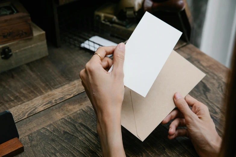 people holding blank paper on a wooden table