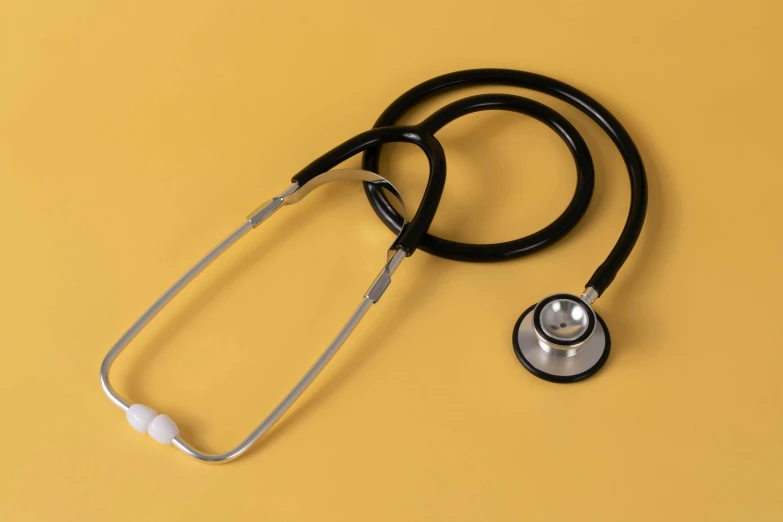 stethoscope and a stethoscope lying on top of yellow paper