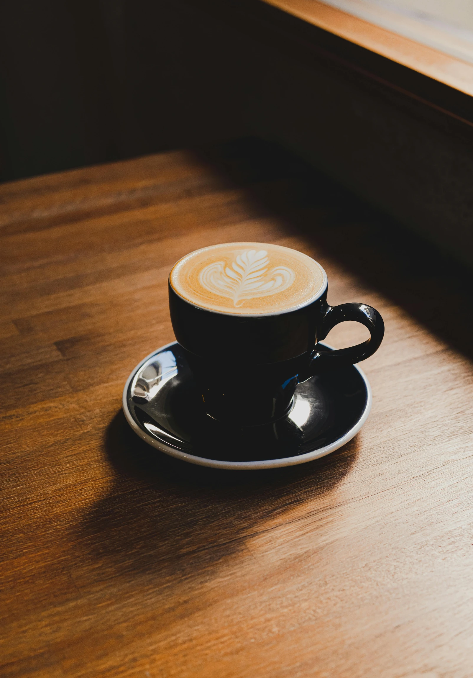 a cup of coffee on top of a wooden table