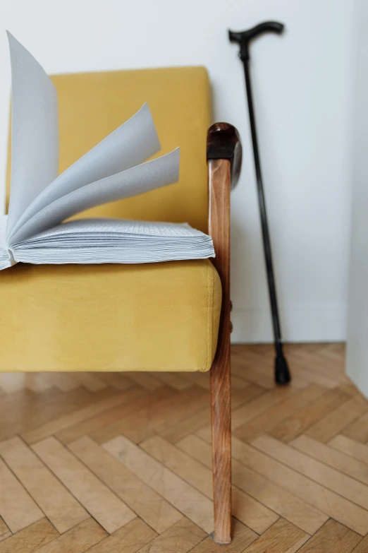 a yellow chair has folded papers and hammers on it