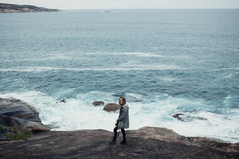 a person standing on top of a rock looking out at the water