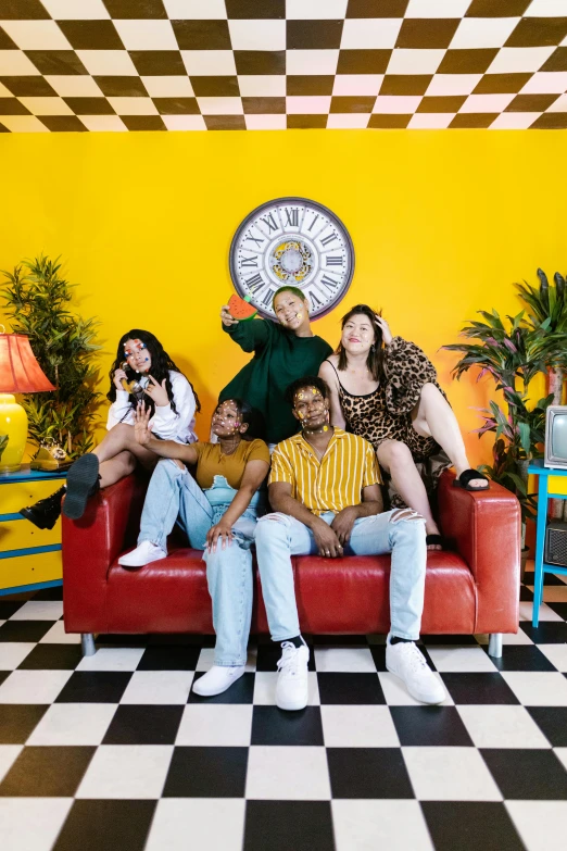 a group of people sitting on top of a red couch