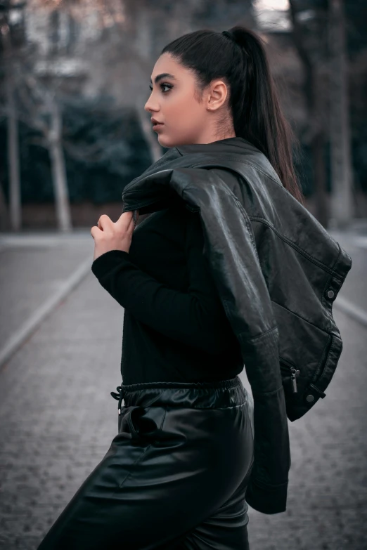 woman in black leather outfit walking down a brick path