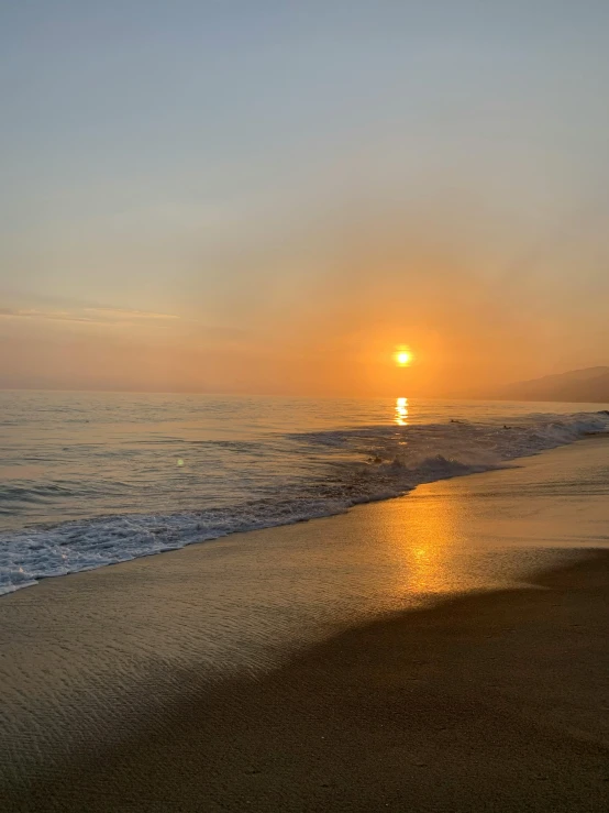 a sunset over the ocean and the waves