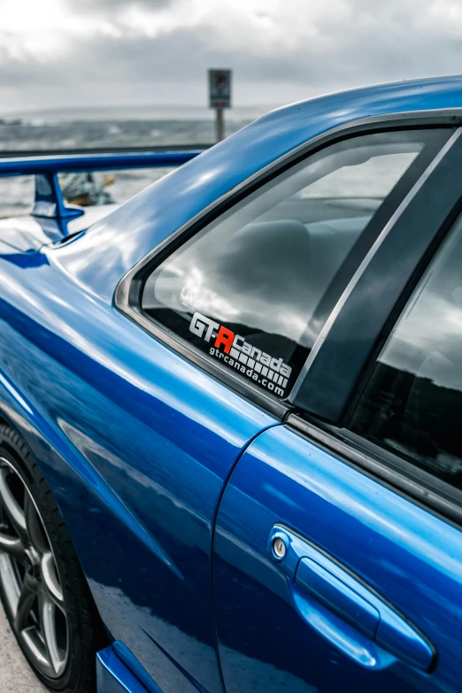 blue car with black trim next to the water