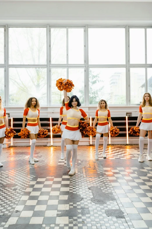 a group of young woman dancing together in front of some windows