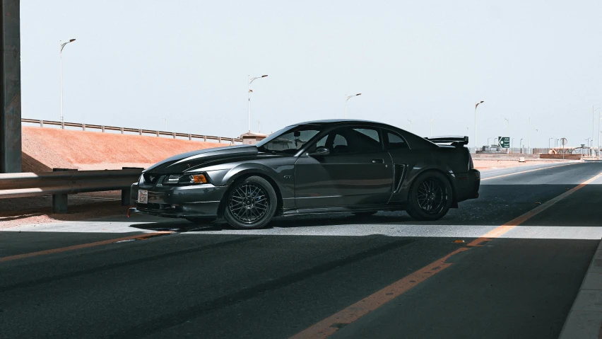 the gray car is stopped on the road by himself