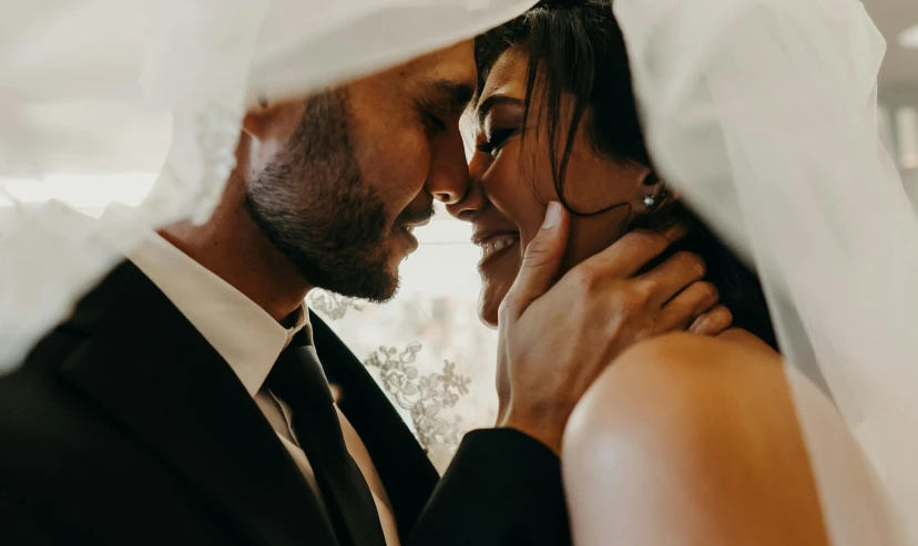 a man and woman in wedding garb sharing a laugh