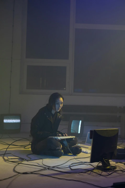 a girl sits on the floor while talking on a cell phone