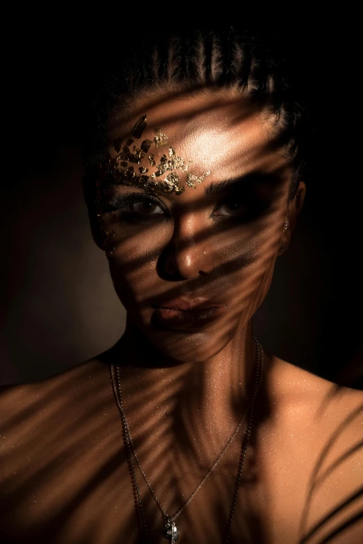 a woman is covered in gold on her face