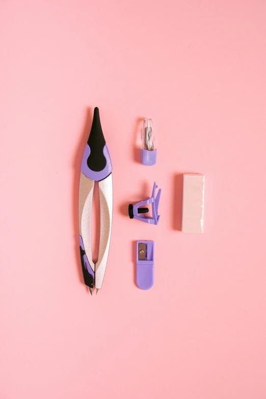 a pink table topped with a scissors, other supplies