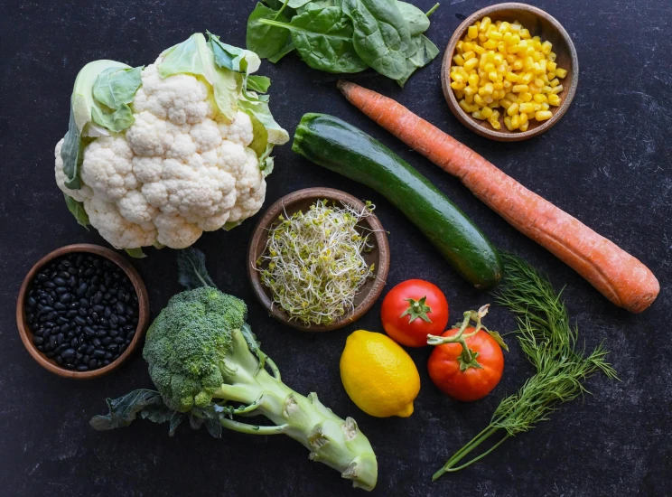 several foods are arranged in bowls on a black counter