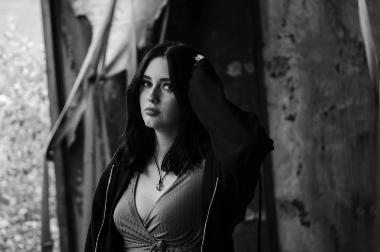 a woman is holding her hair up in black and white