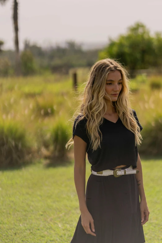 a women with long hair standing in a field