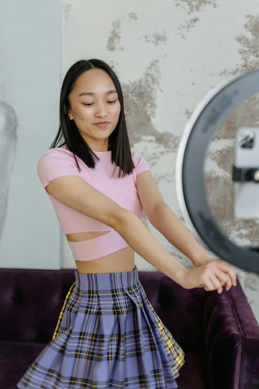 woman posing in front of mirror wearing plaid skirt