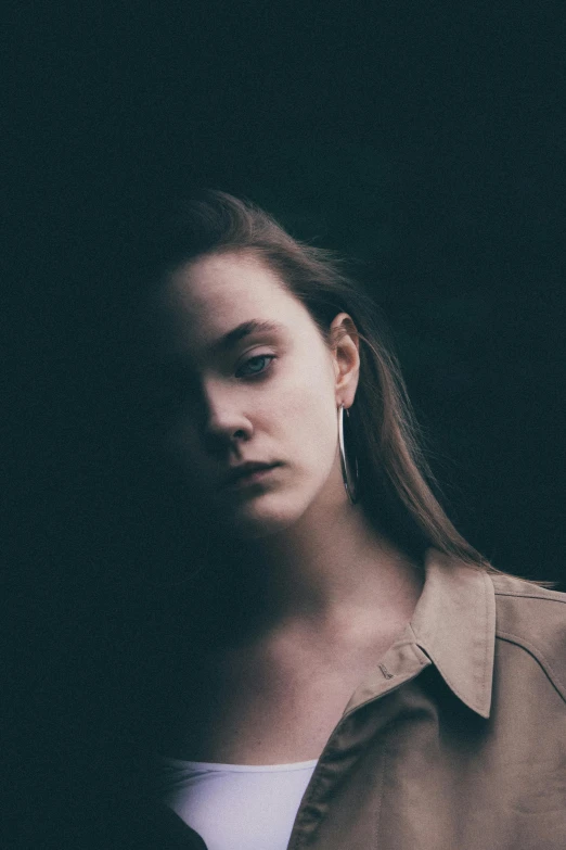 a woman looking straight ahead while wearing big earrings