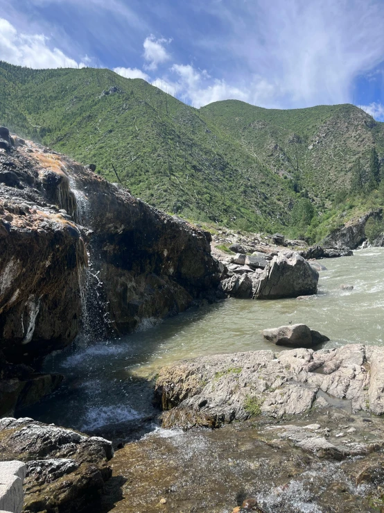 a rocky body of water with a waterfall in it