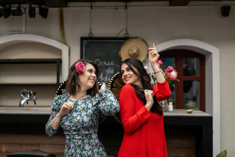 two women holding flowers are taking pictures