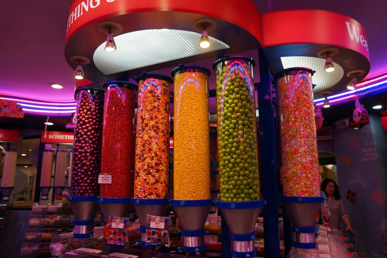 a display with many different colored candies in front of a sign