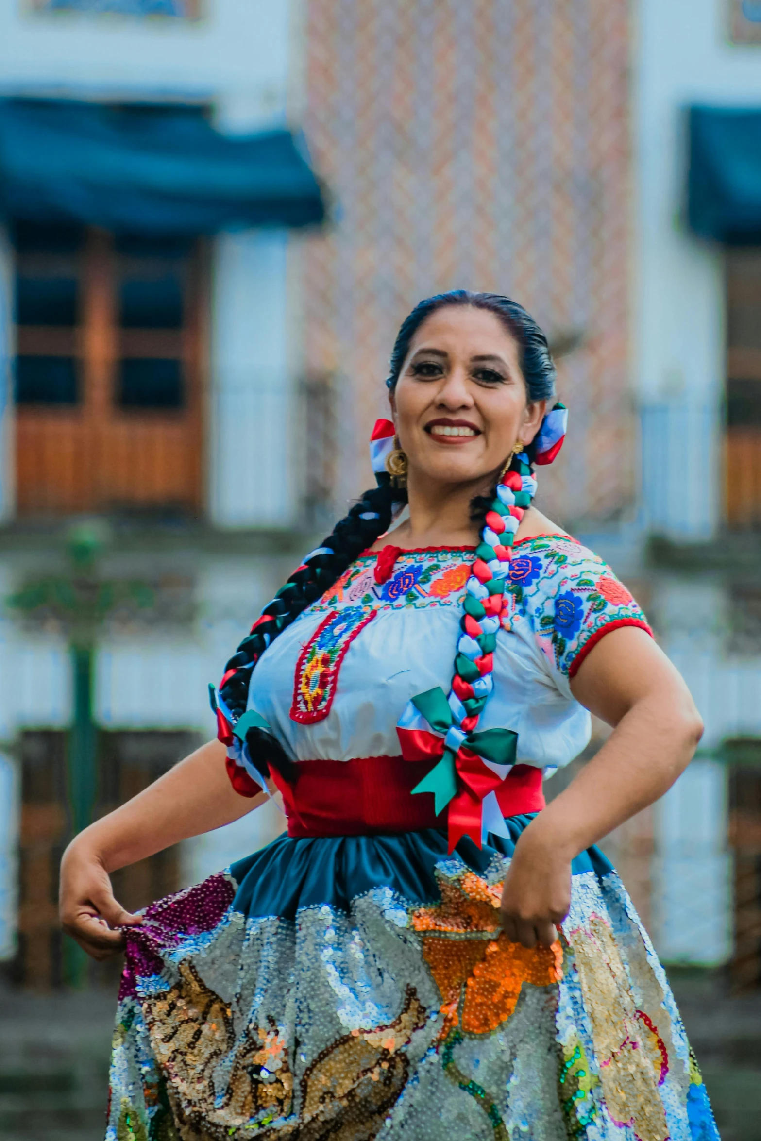 woman in mexican dress standing outside in front of a building