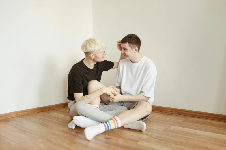 two boys sitting next to each other on the floor