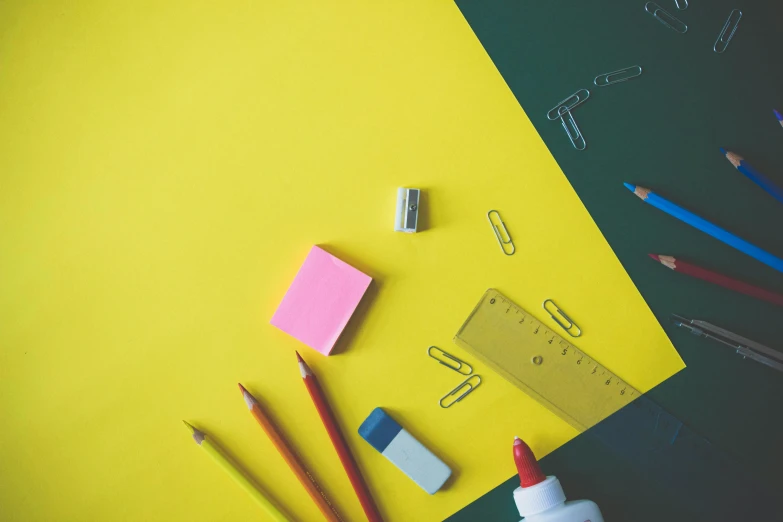 a bunch of pencils, erasers and eraser blocks on yellow paper