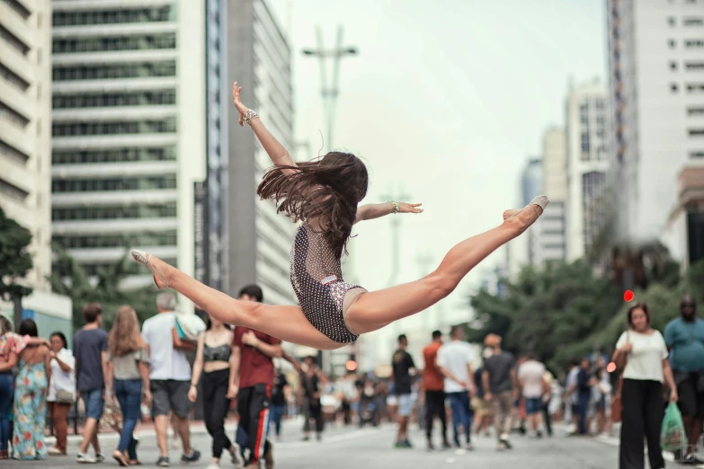 the woman is balancing on her legs and looking like she was dancing in the street