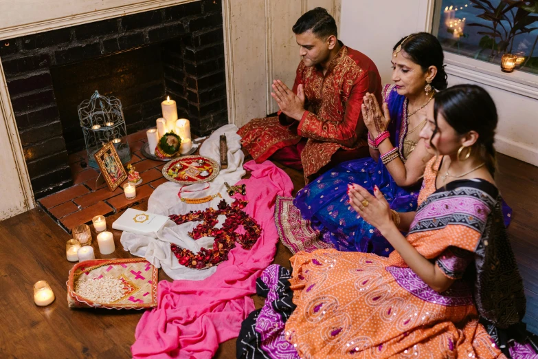 a man and a woman dressed in indian attire next to a decorated table