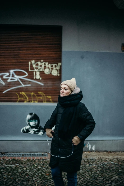 an old woman standing in front of a graffiti covered building