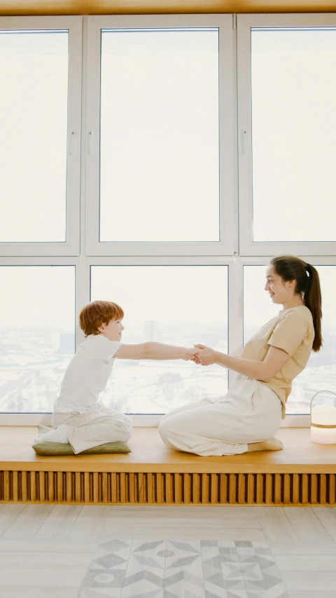 an image of a mom and son sitting on the window sill together