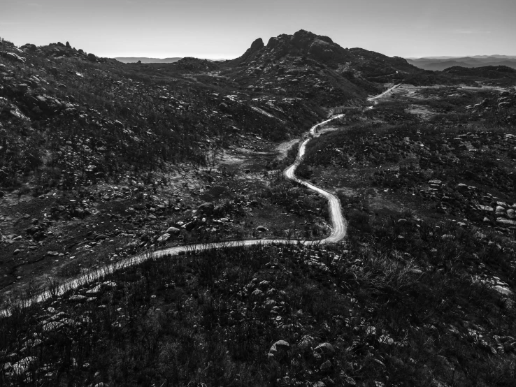 a winding mountain road through some grass