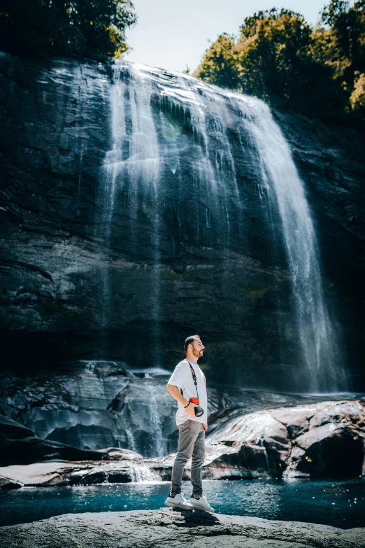 a man with a camera near a waterfall