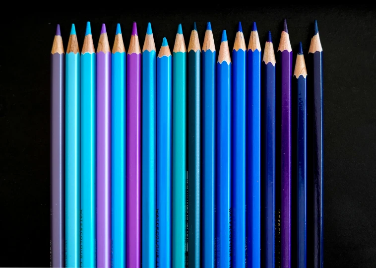 a group of blue and purple pencils are lined up together