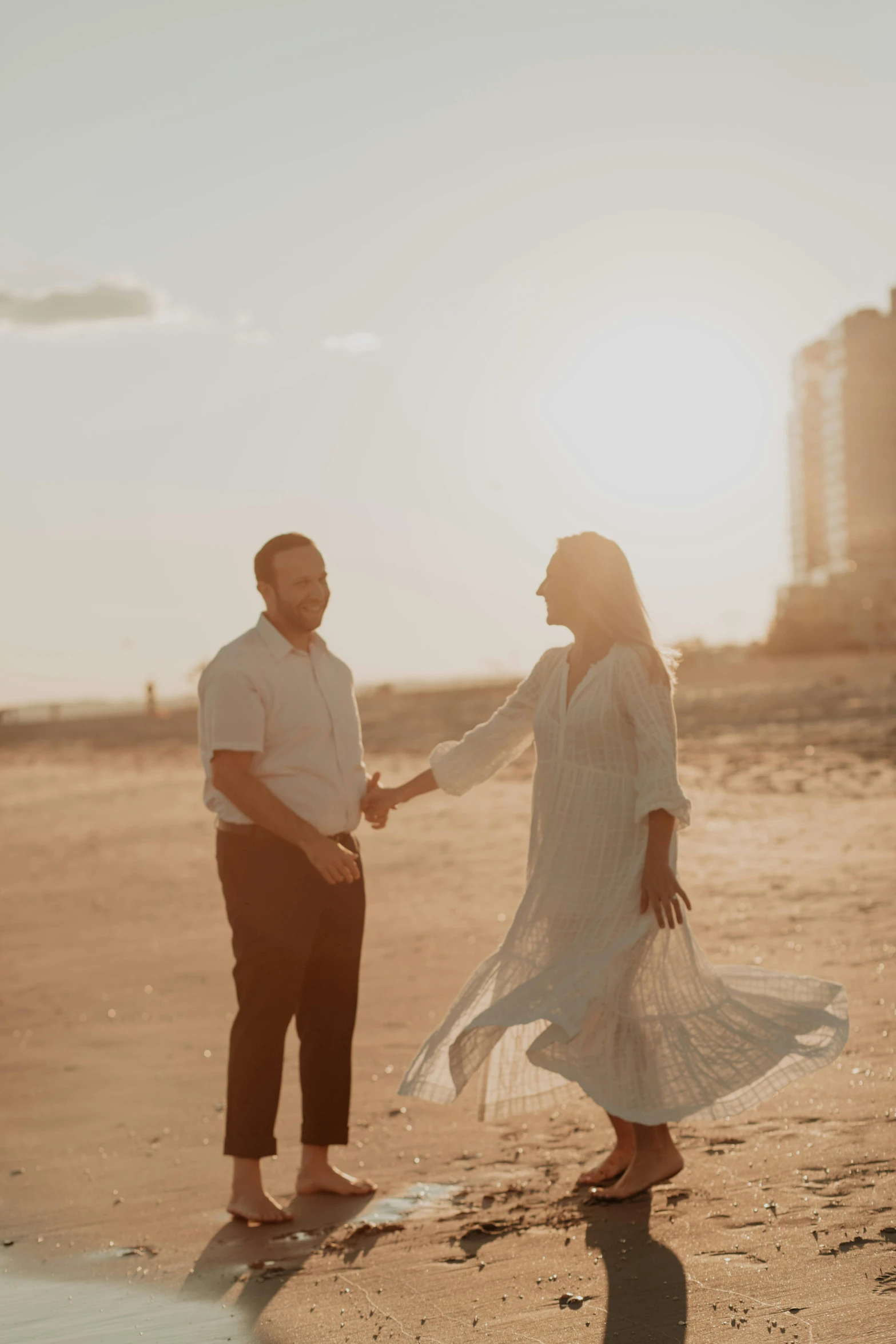 a man and a woman holding hands on the beach