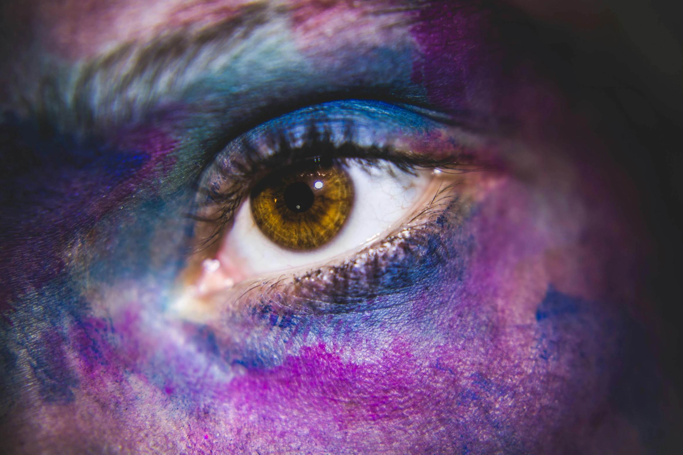 a close up of the eyes of a person with a painted look on their face