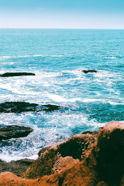 the body of water next to a large rocky cliff