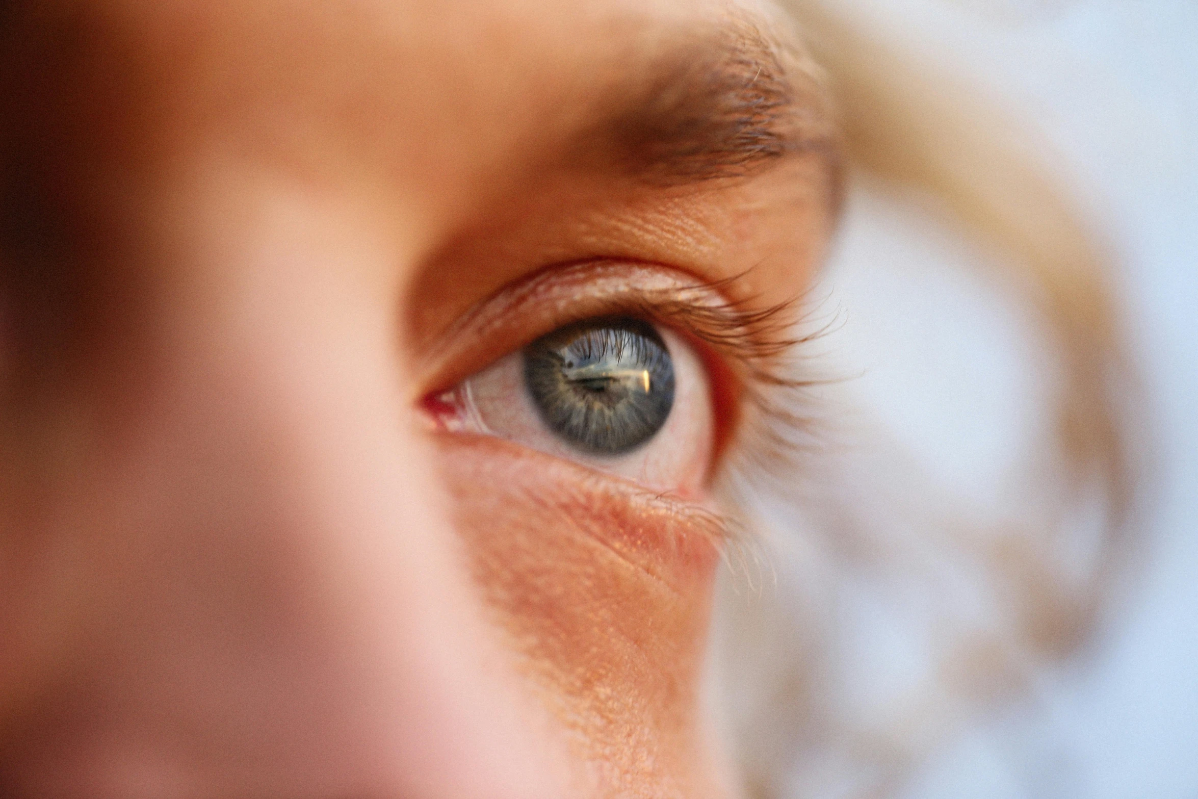 a woman with large blue eyes and gold thread around the iris