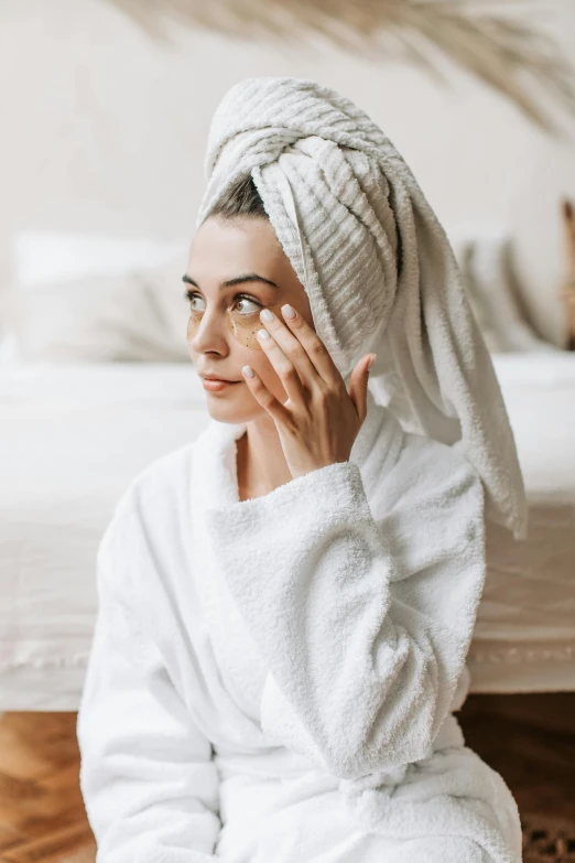 a  with white towels on her head and covering her eyes