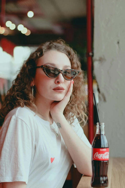 a girl sits at a bar and drinks a beverage