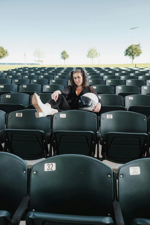 a woman sitting on top of a chair in front of a large crowd