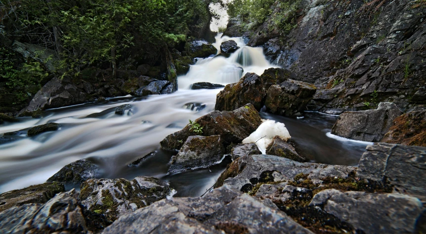 a river surrounded by mountains with rocks in it