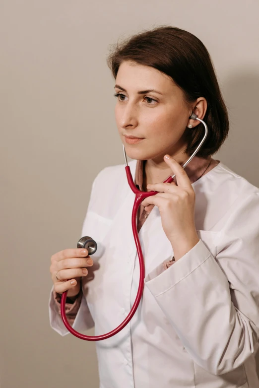 the nurse is holding her stethoscope up to her face