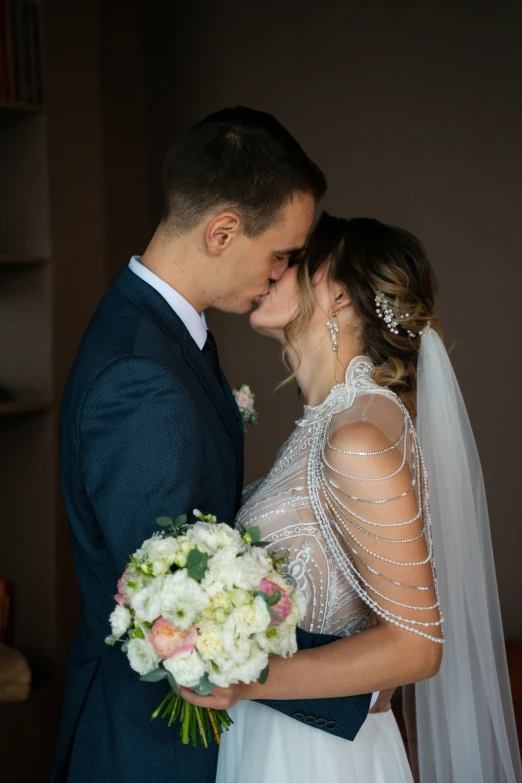 the bride and groom smile into each others'eyes as they hug