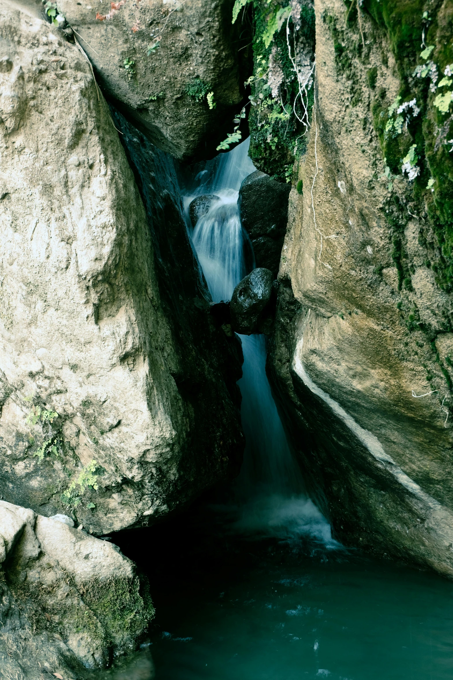 waterfall flowing down into the river below two rocks