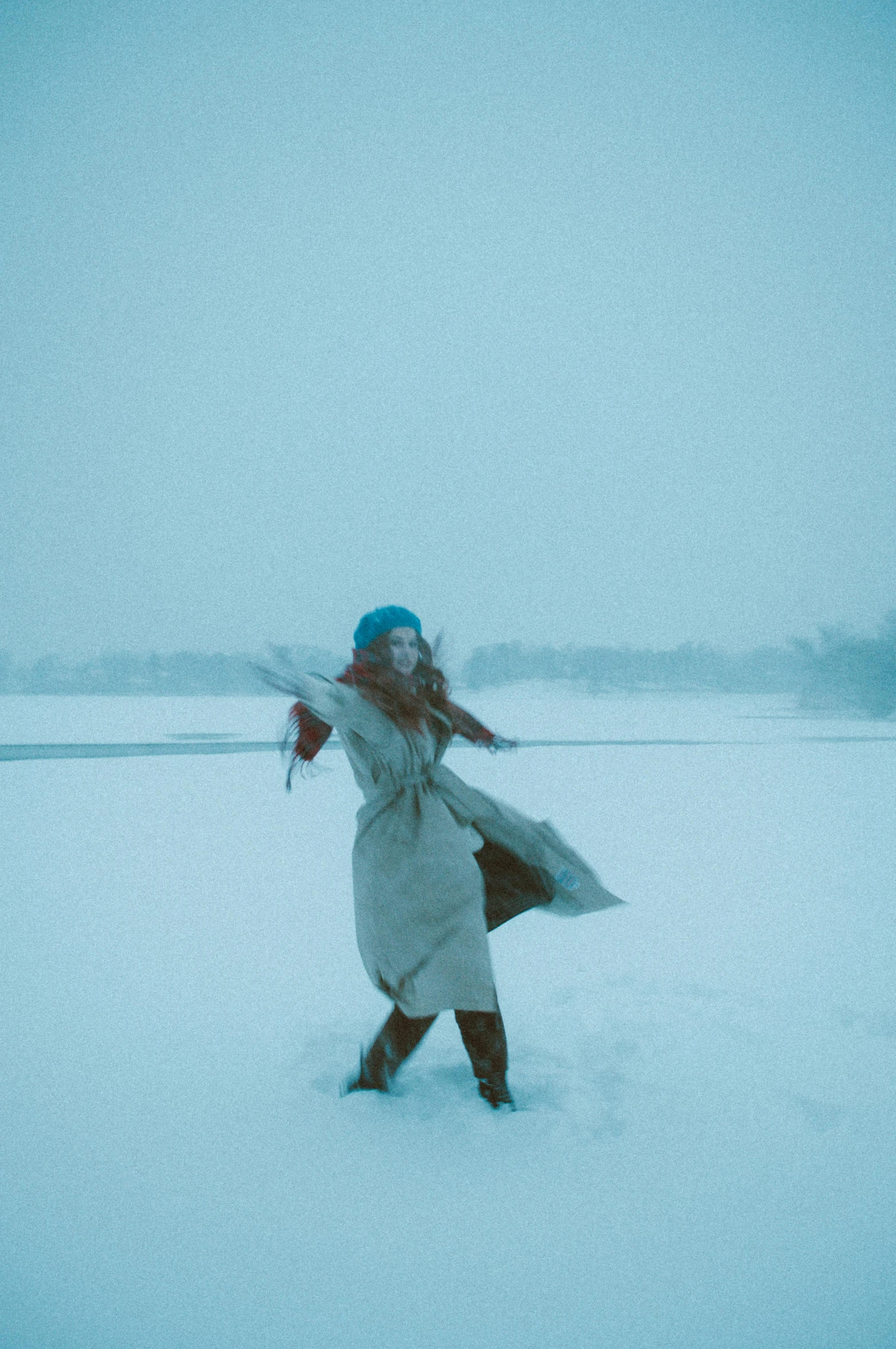 a woman walking across a snow covered field