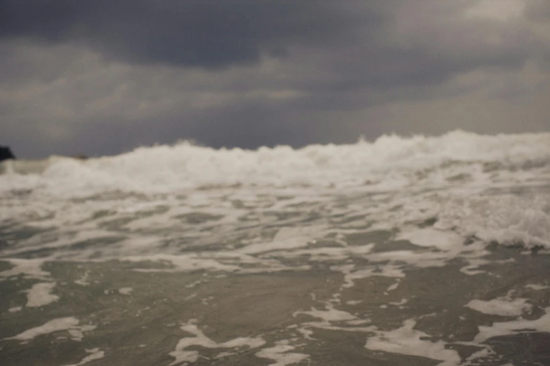 a surfboard sitting in the middle of a dark ocean