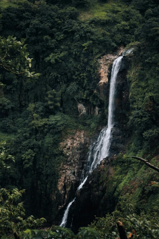 a very tall waterfall with many trees around it